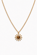 Gold necklace with a sun-shaped pendant on a white background